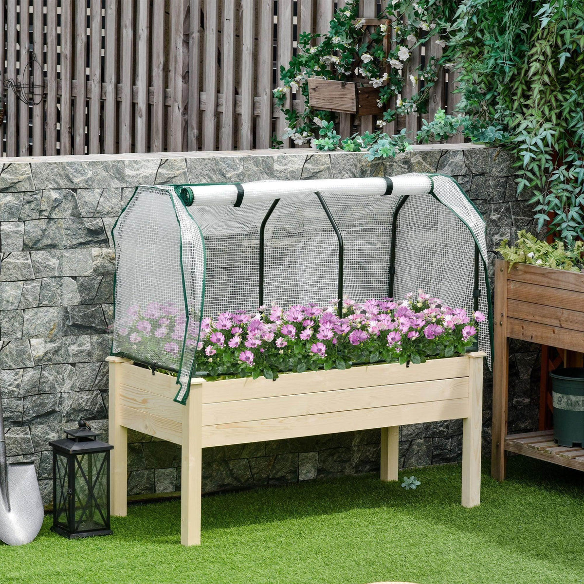 Wood planter box with greenhouse cover, white mesh sides and pink flowers in raised bed