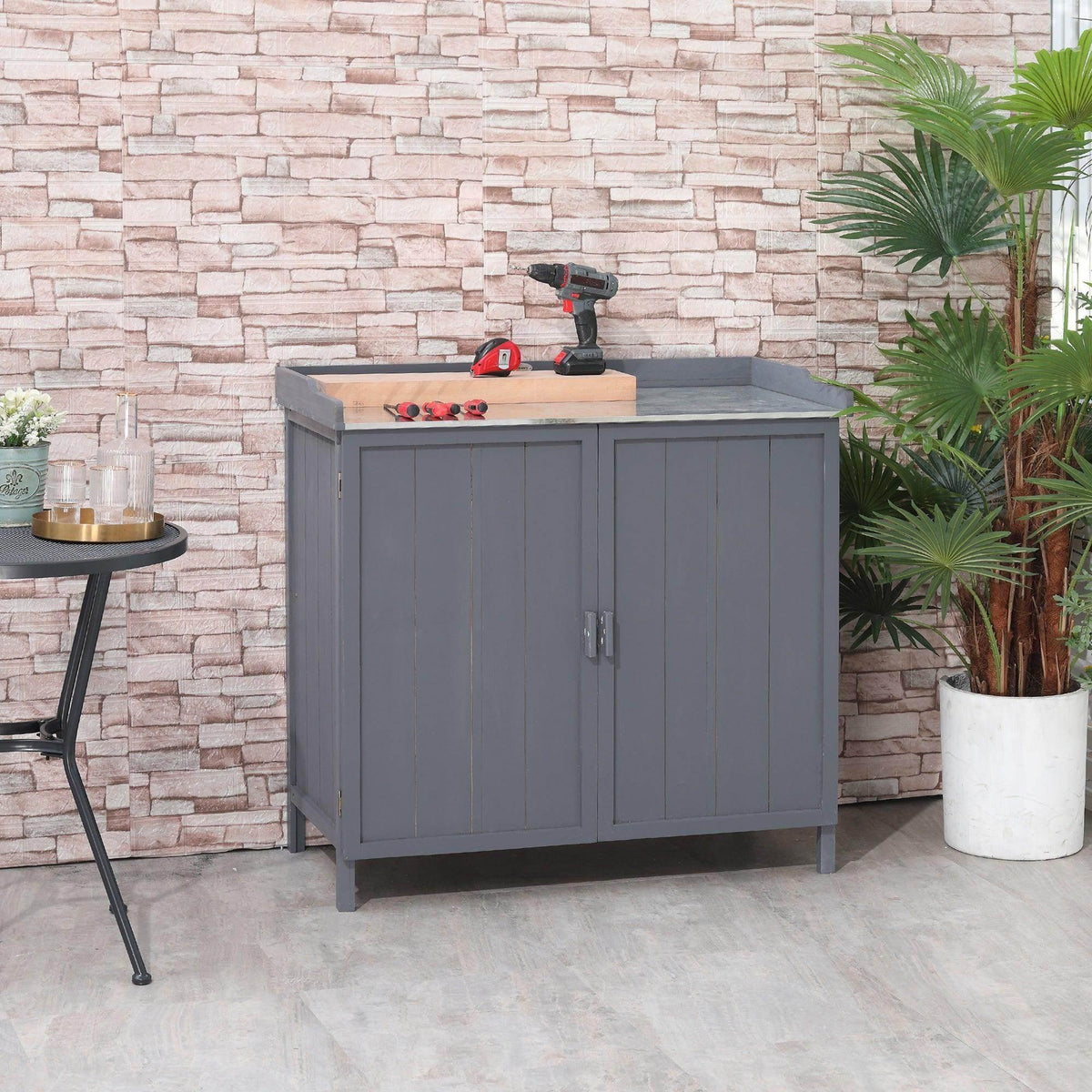 Grey wooden garden storage shed with potting bench and two-door cabinet front
