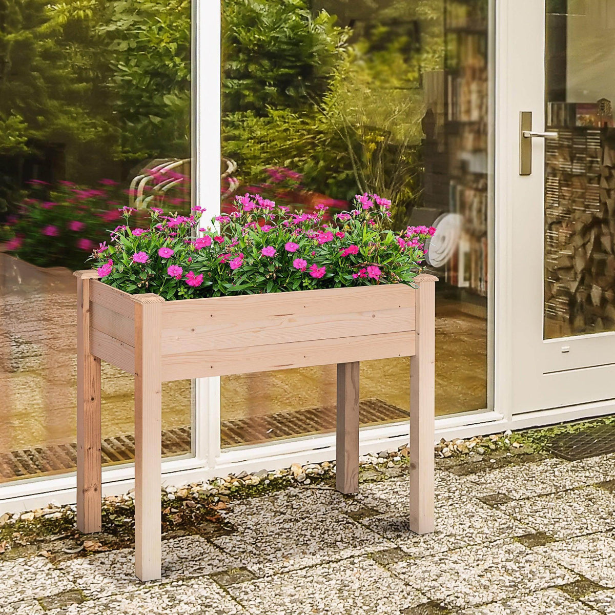 Light wood raised garden planter with pink flowers on four white legs