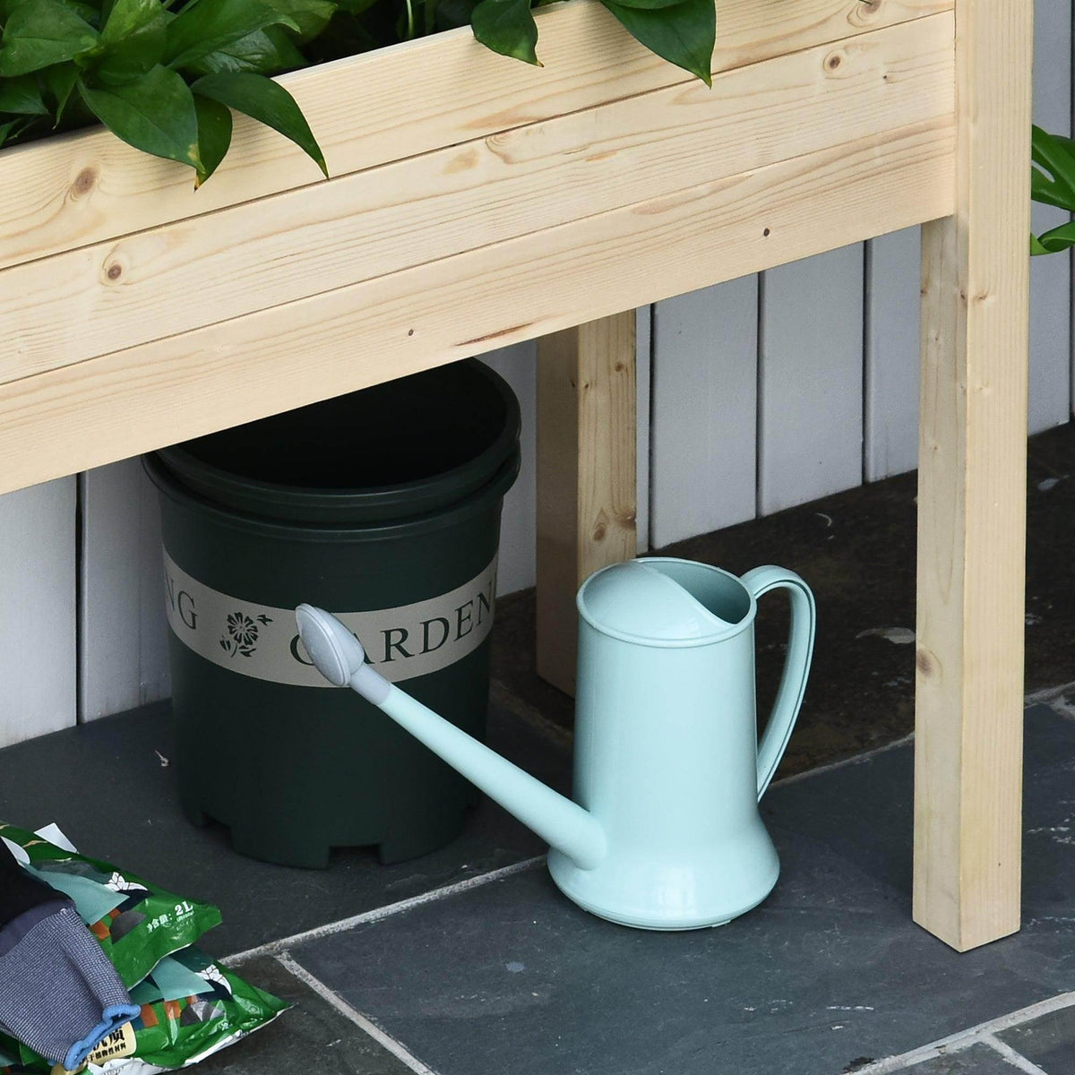 Wood raised garden planter base with watering can and pot under the bed