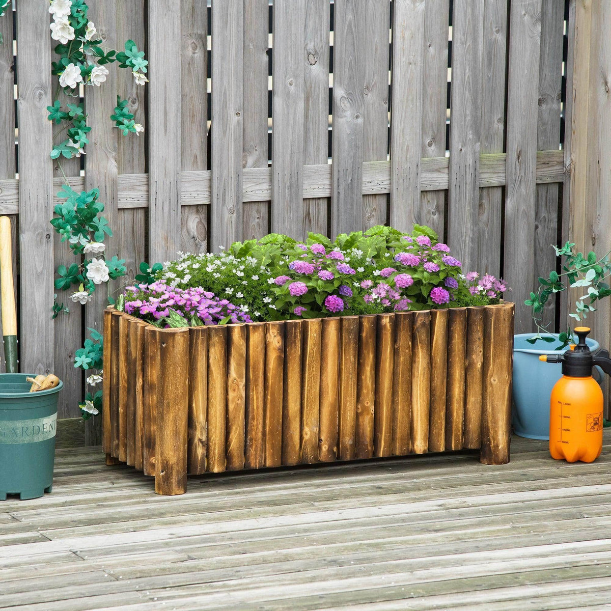 Wooden raised flower bed planter with vertical slats, filled with purple flowers