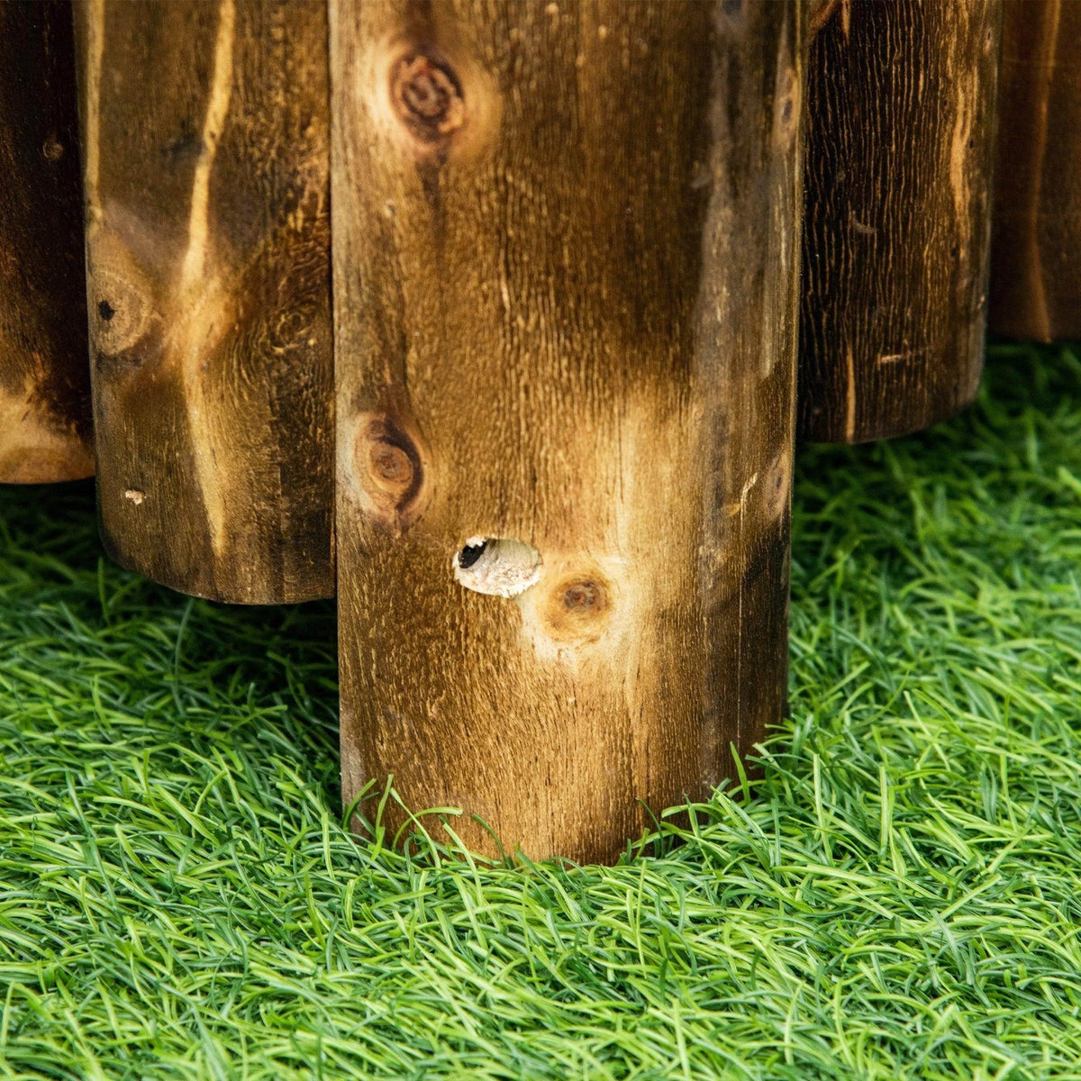 Wooden raised bed corner post close-up on green grass