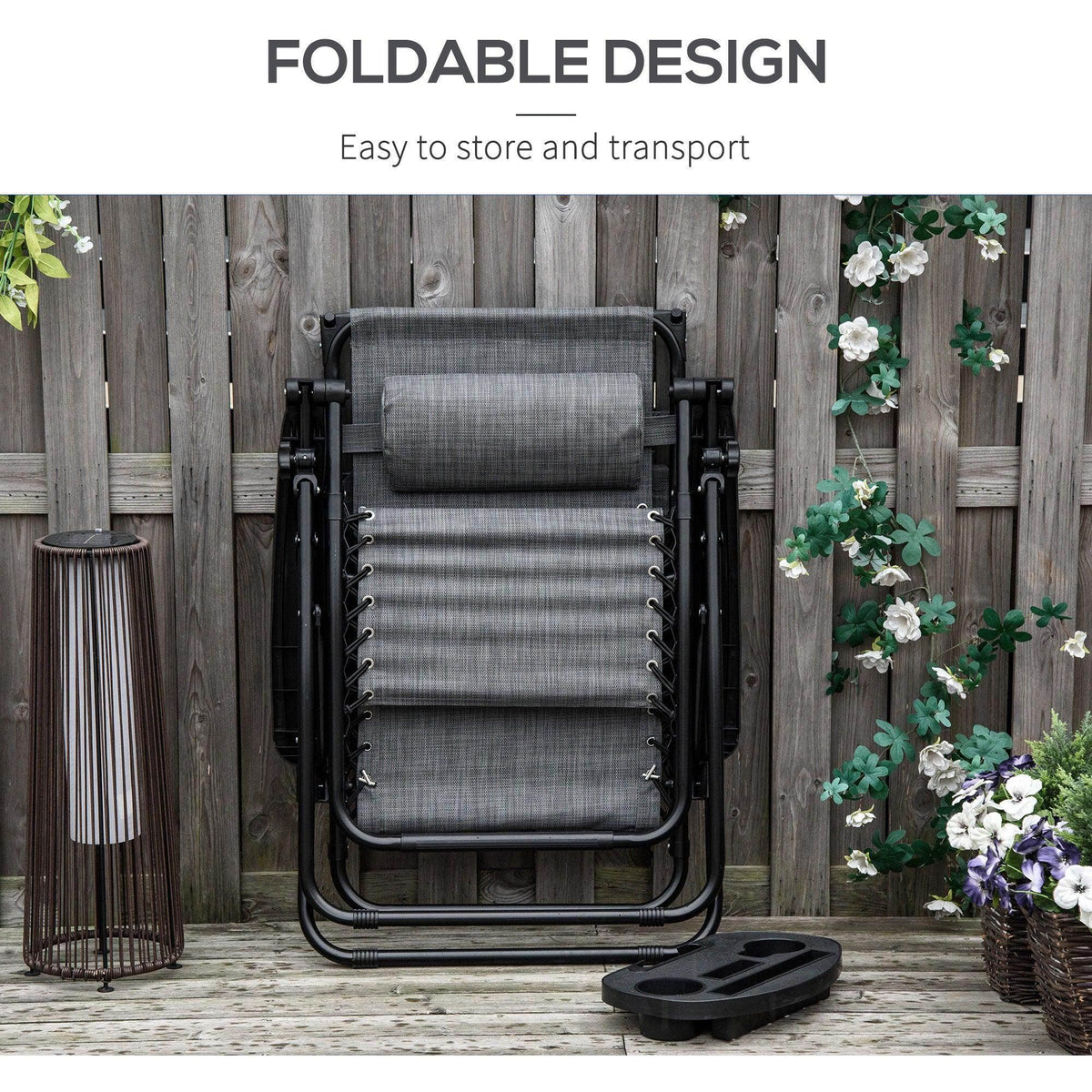 Folded grey padded reclining chair with black frame against wooden fence.