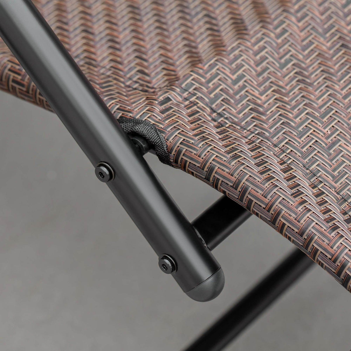Black tubular base with fabric tie wrap and fastener on brown zero gravity chair