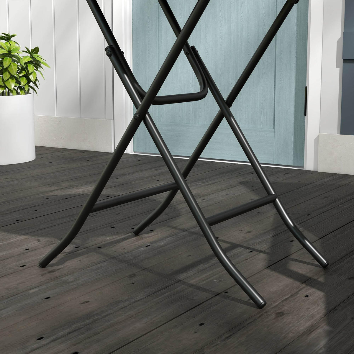 Bottom view of foldable round wicker side table with black metal legs on floor