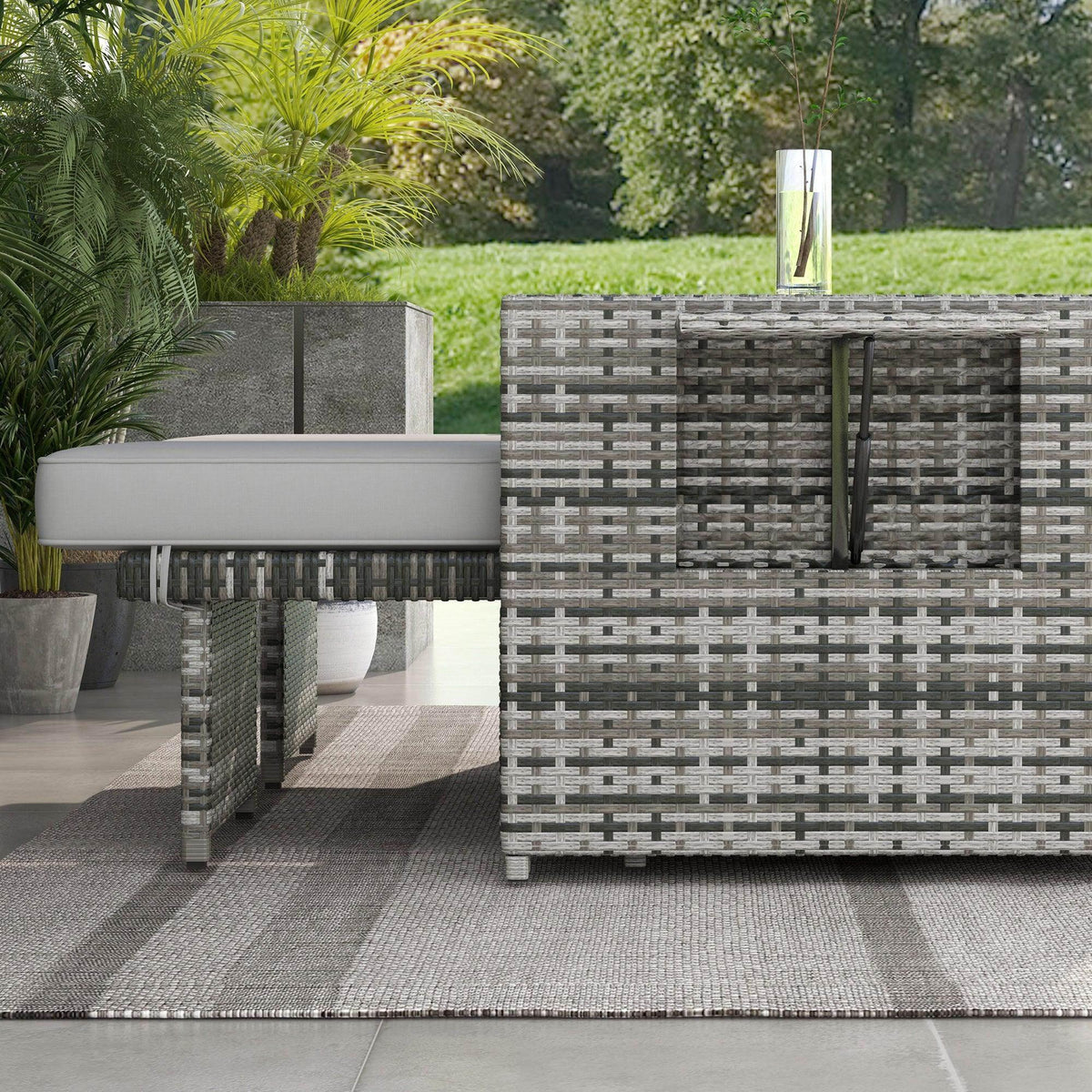 Grey rattan outdoor lounge chair with storage ottomans and matching seat cushions