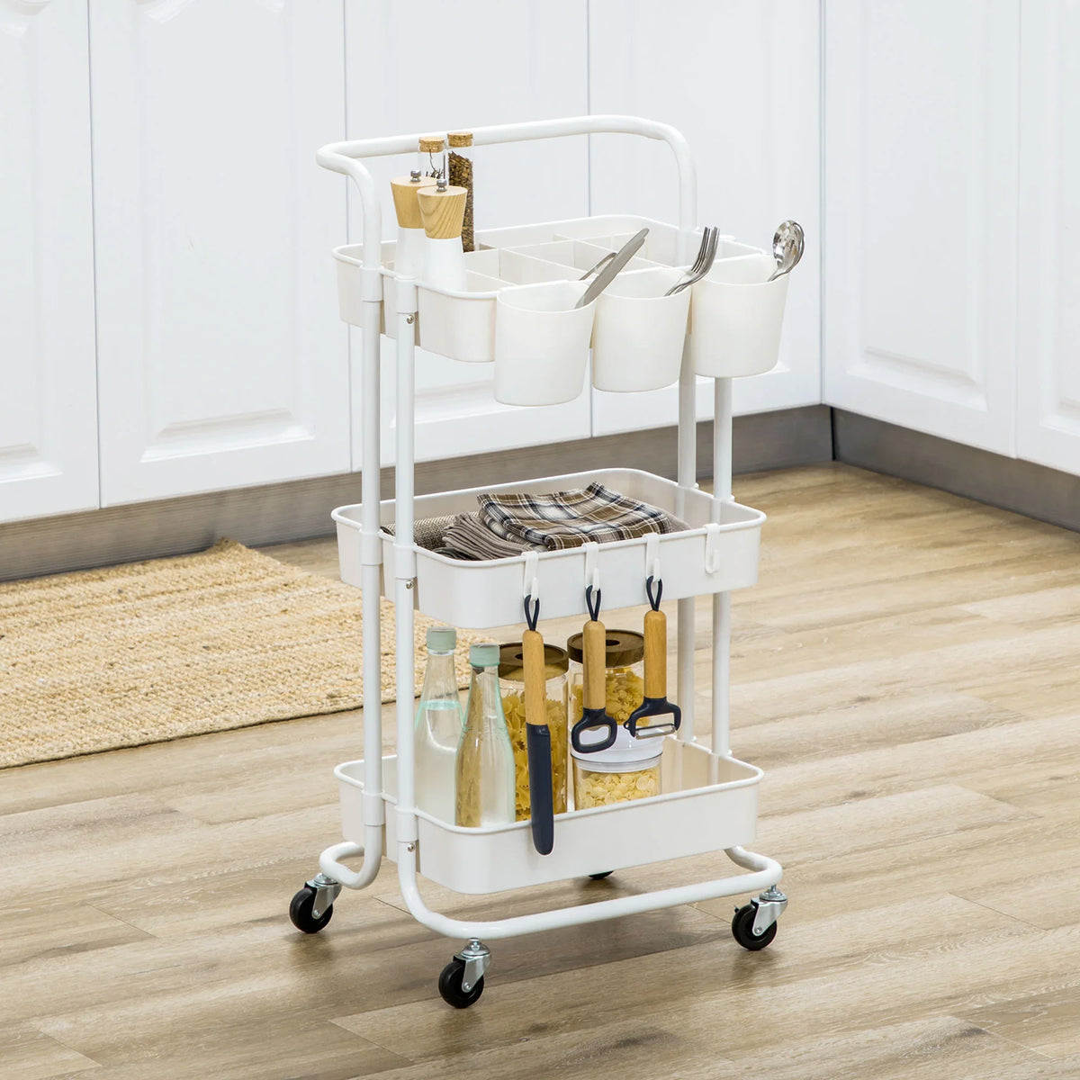 White three-tier trolley cart with baskets and hanging utensil holders on wheels