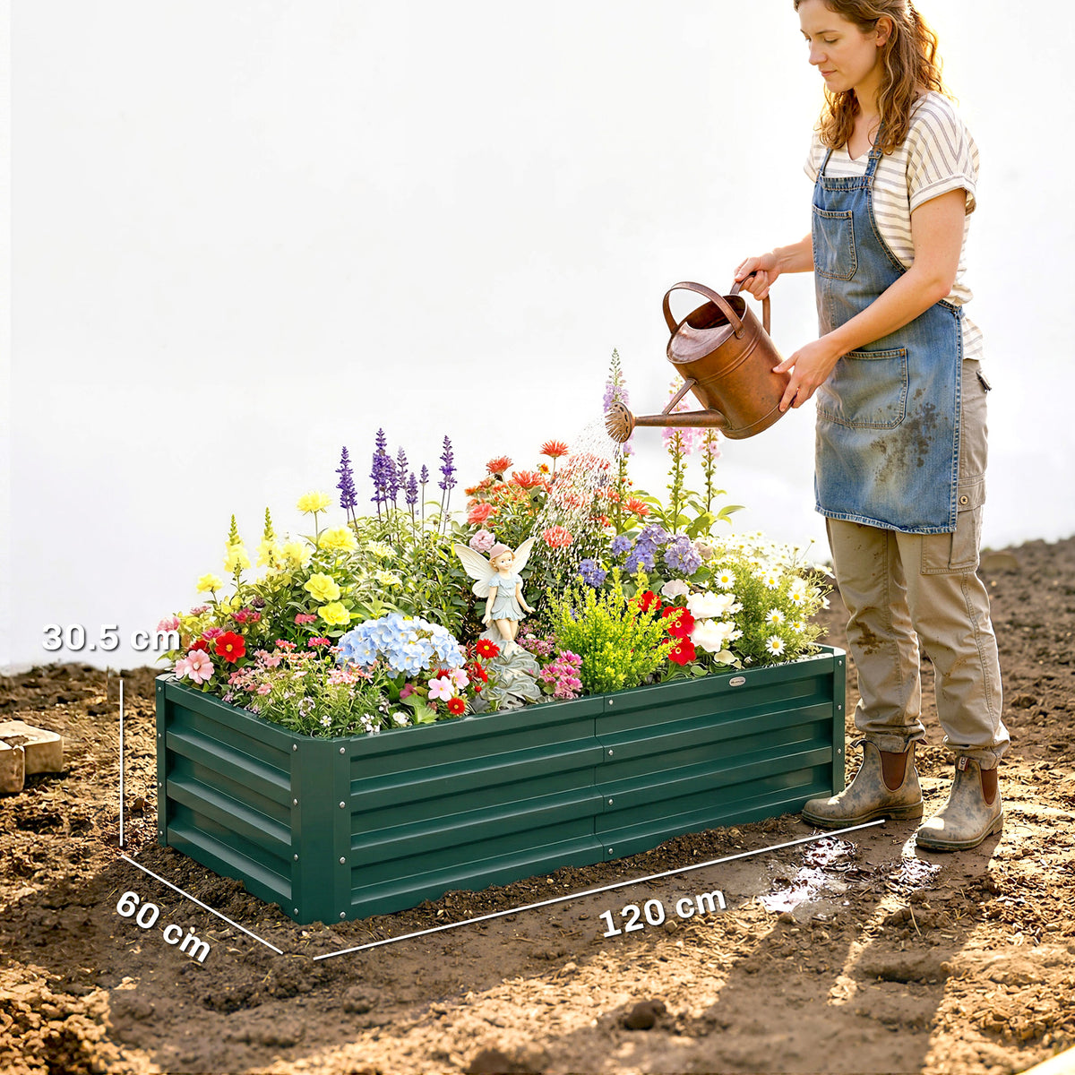 Green raised garden bed set with flowers and herbs, with a person pouring water.