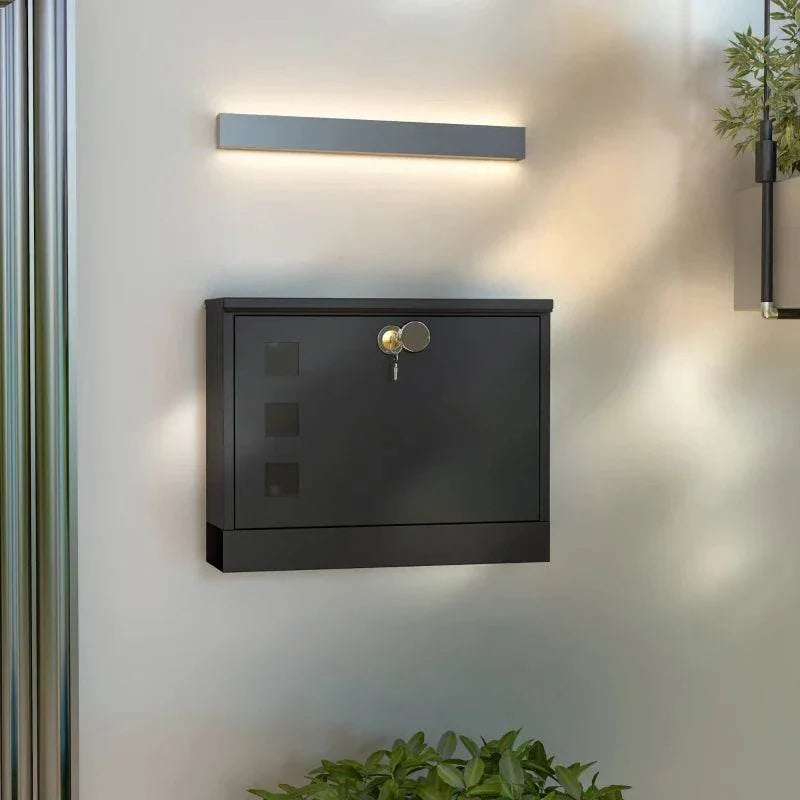 Wall-mounted black mailbox with front viewing windows and circular lock knob