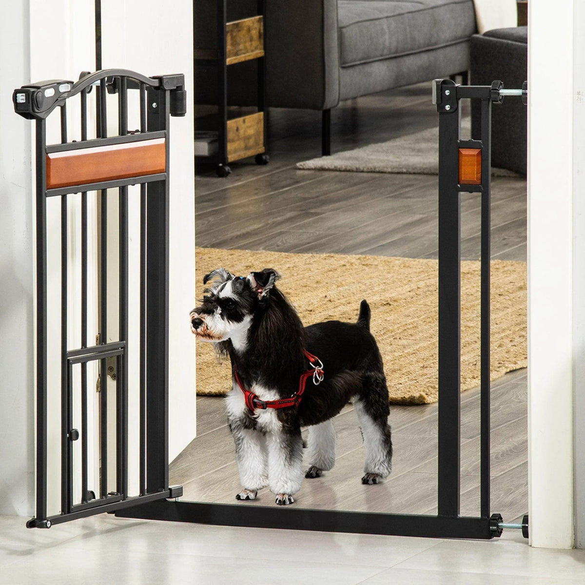 Black metal pet gate with wooden center panel and side latch, hinged open doorway