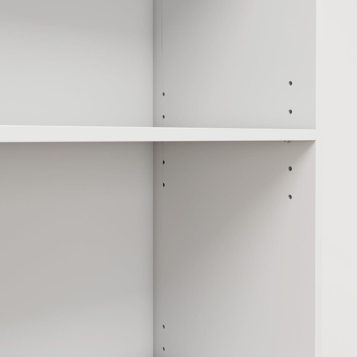 White bookcase interior showing shelf pin holes for adjustable shelf positions.