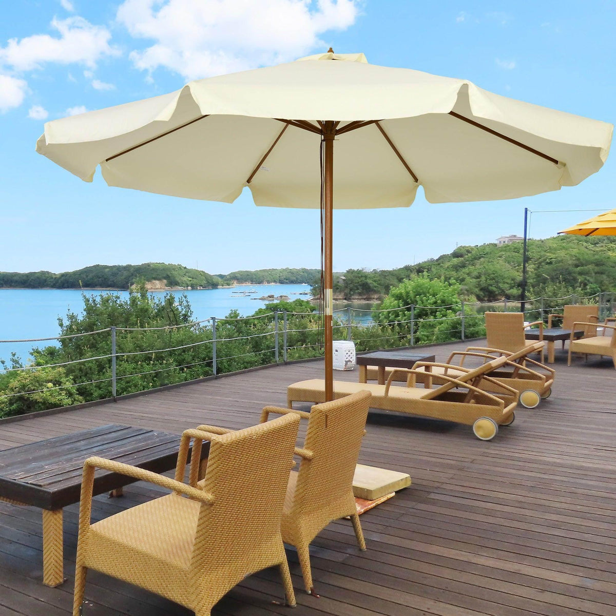 Beige patio umbrella with ruffled canopy and wooden bamboo pole, outdoor patio setting.