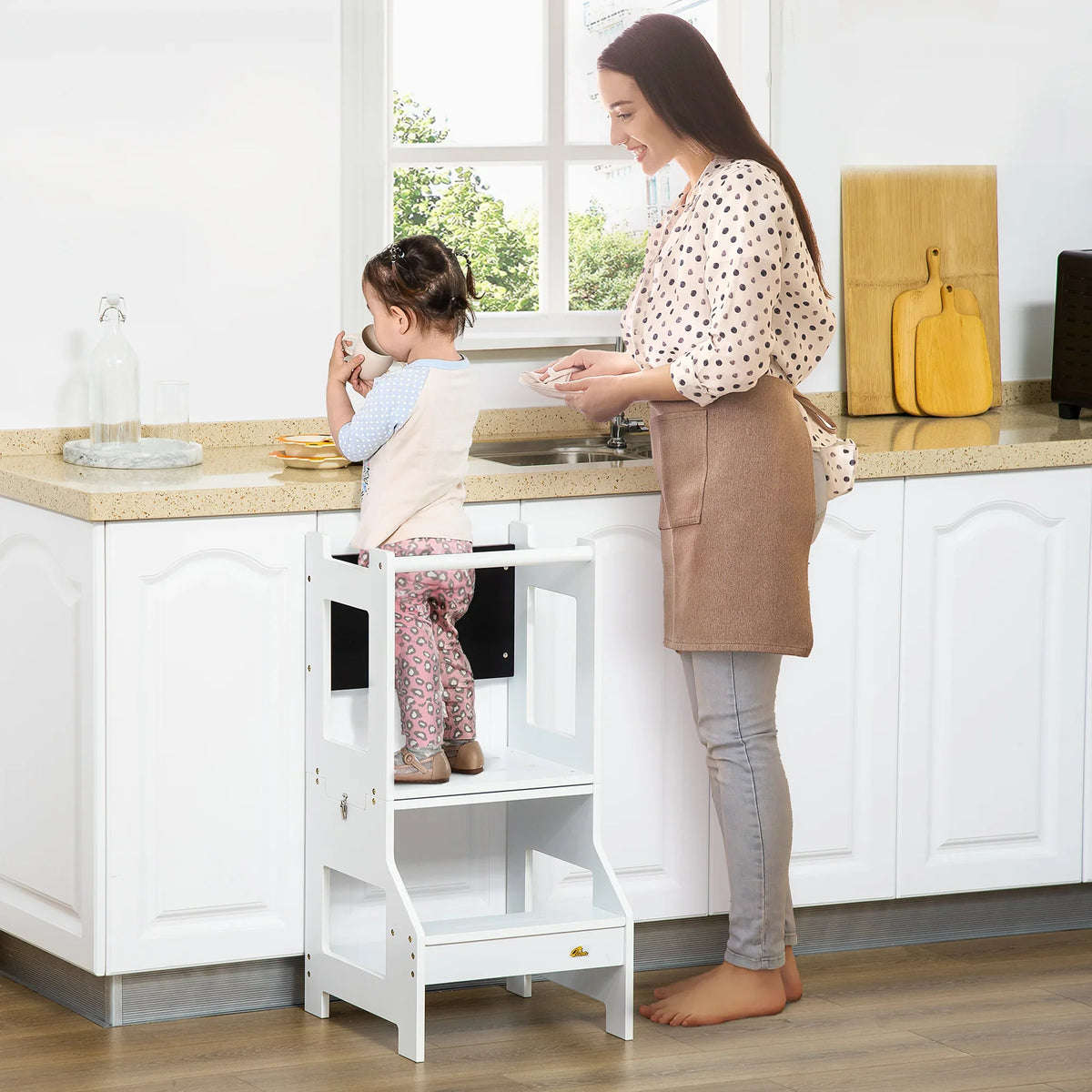 White toddler step stool with safety rail and chalkboard back, near sink