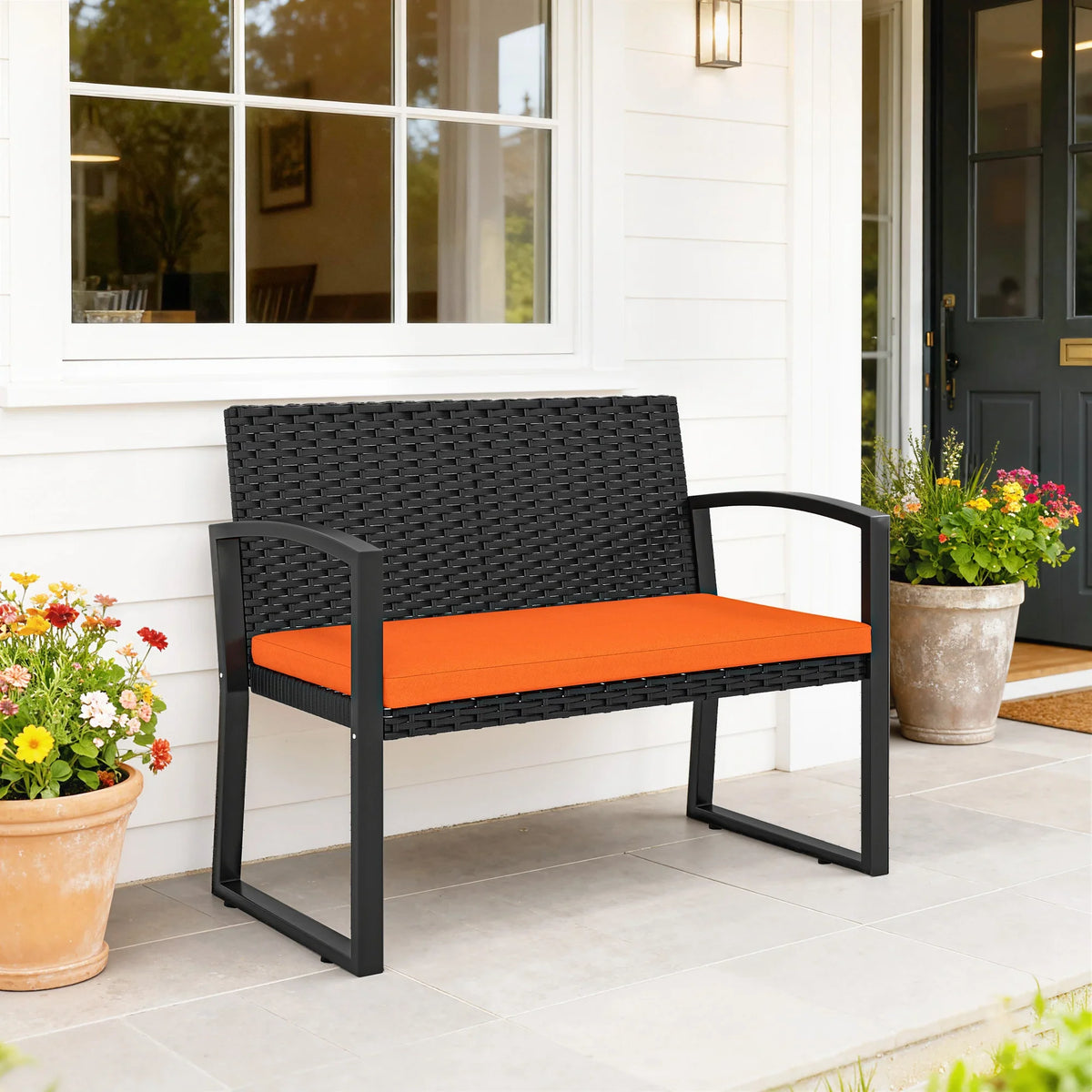 Two-seat outdoor bench with black woven backrest, orange seat cushion, and armrests