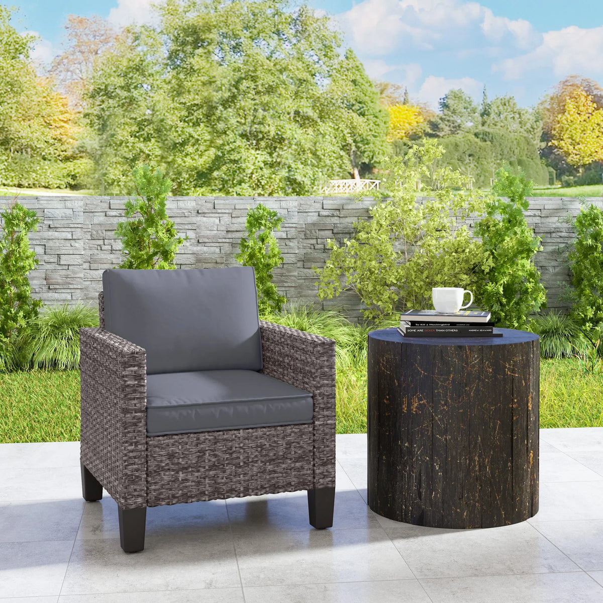 Grey rattan outdoor armchair with dark grey cushions and sloped backrest