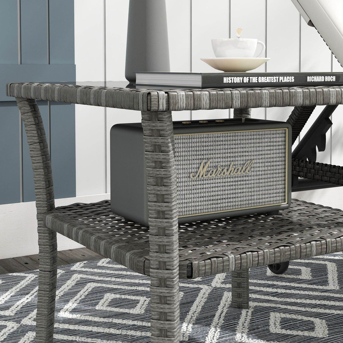 Grey PE rattan two-tier outdoor table with lower storage panel and sturdy legs