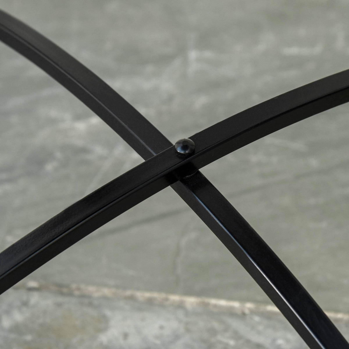 Close-up of black metal crossbar support on round bistro table