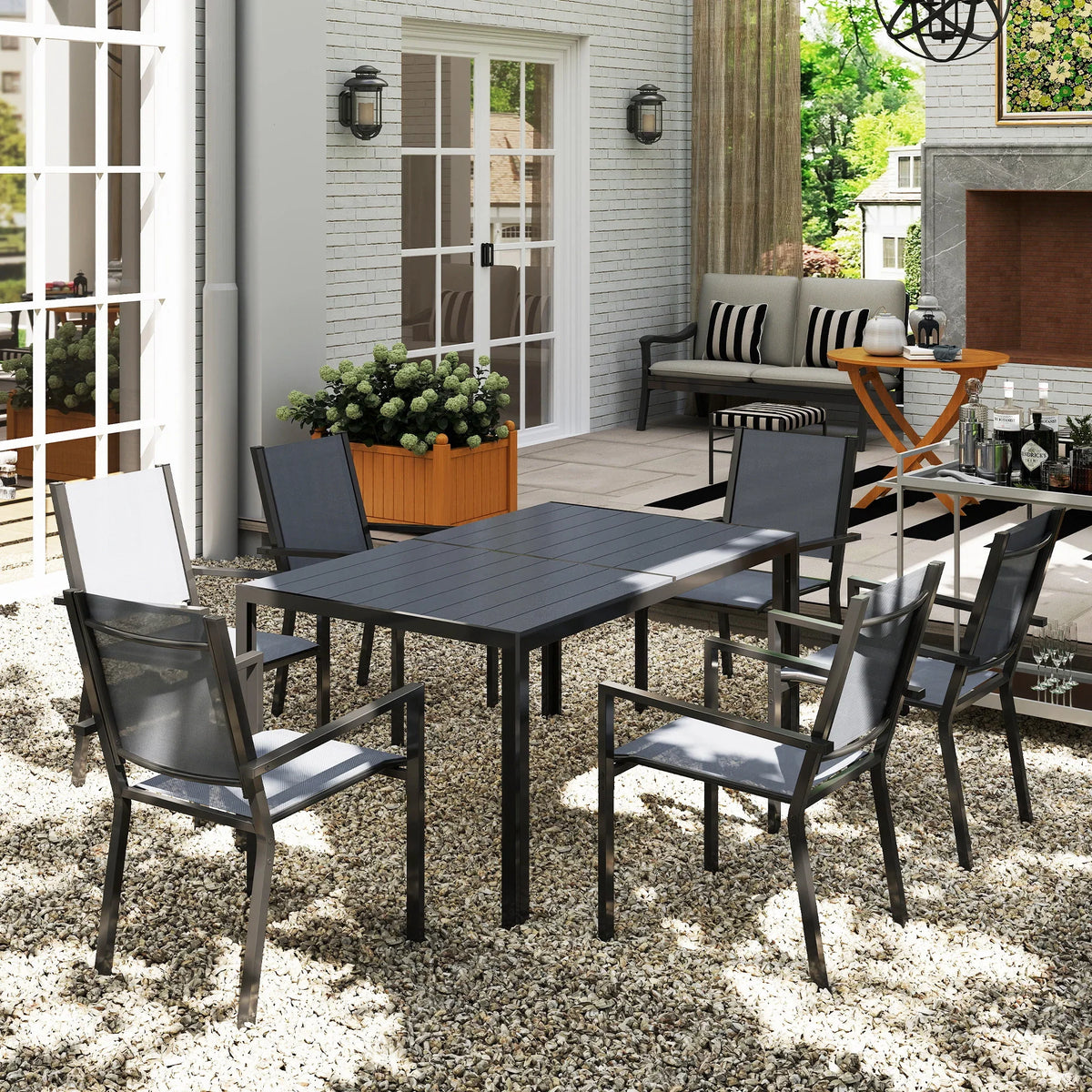 Outdoor dining table with matching stackable chairs, dark gray frames and cushions