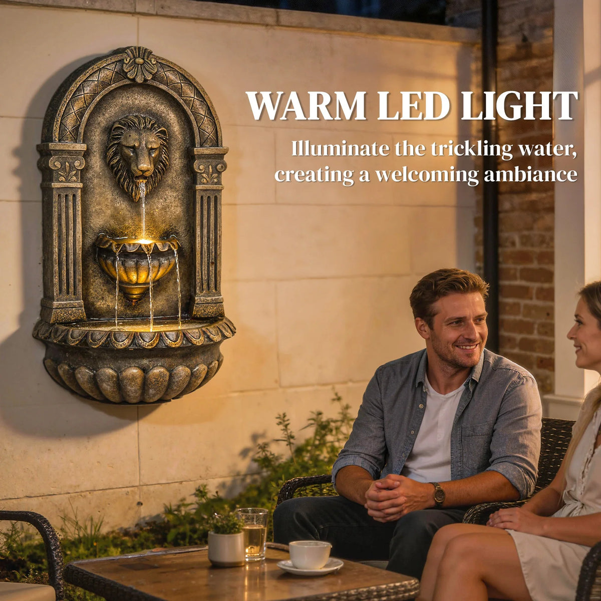 Wall-mounted lion-head fountain with warm LED glowing water tiers on a patio wall