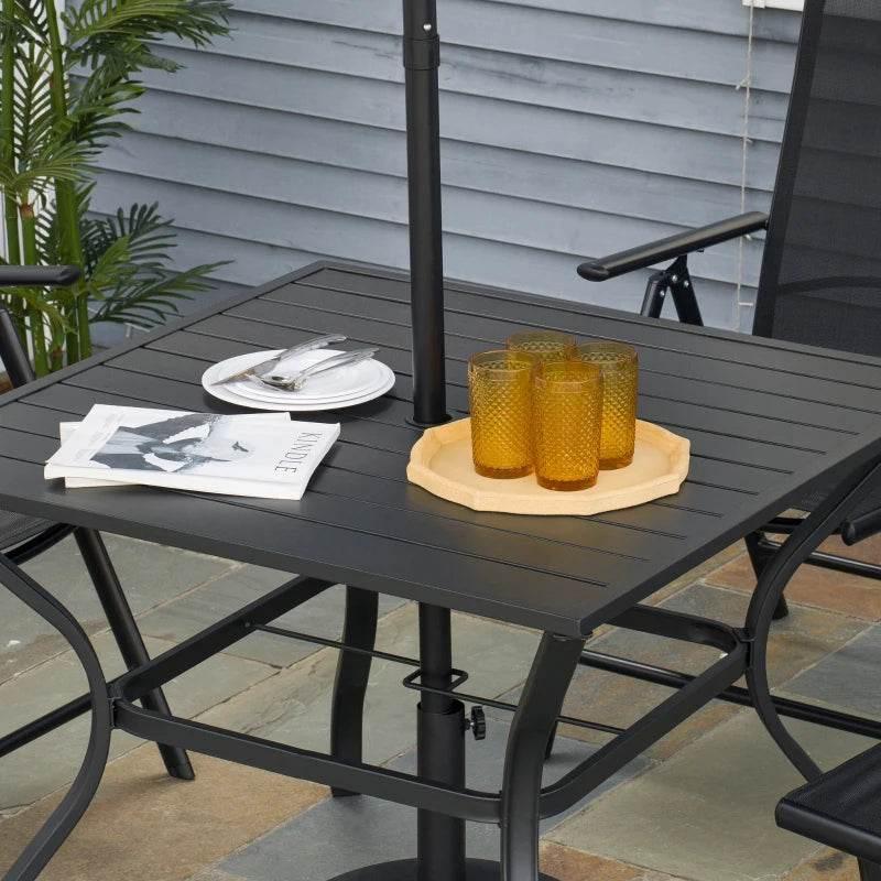 Black outdoor dining table with slatted top holding plates and candles