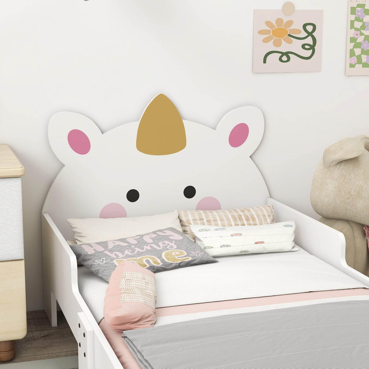 White unicorn toddler bed with horn-and-ear headboard, pillows and blankets
