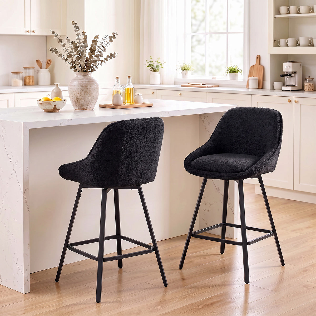 Two black upholstered counter-height bar stools with curved backrests and slim black legs