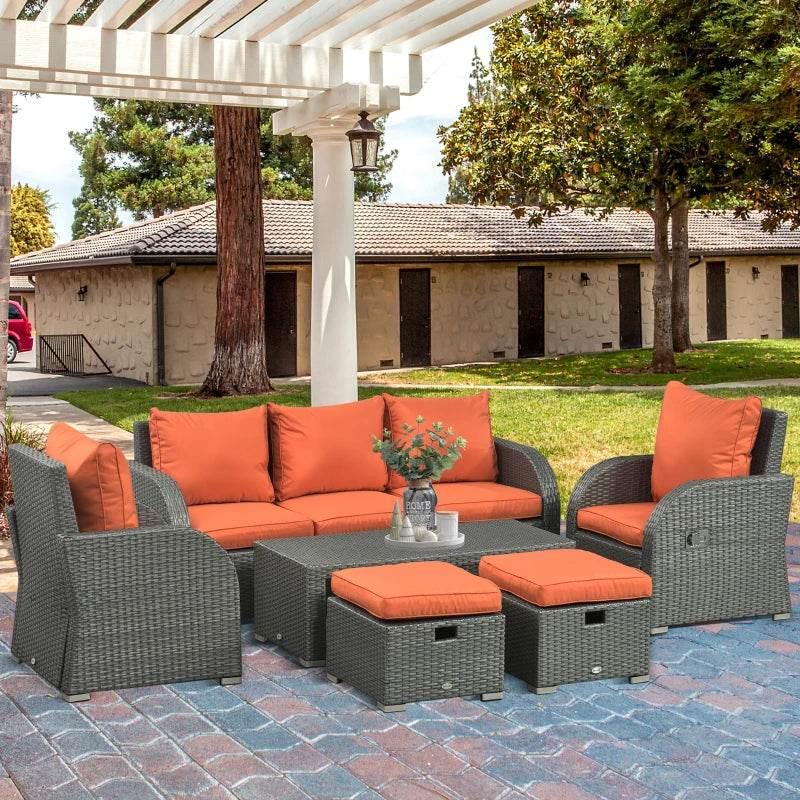 Outdoor rattan dining set with orange cushions on gray reclining chairs and matching sofa