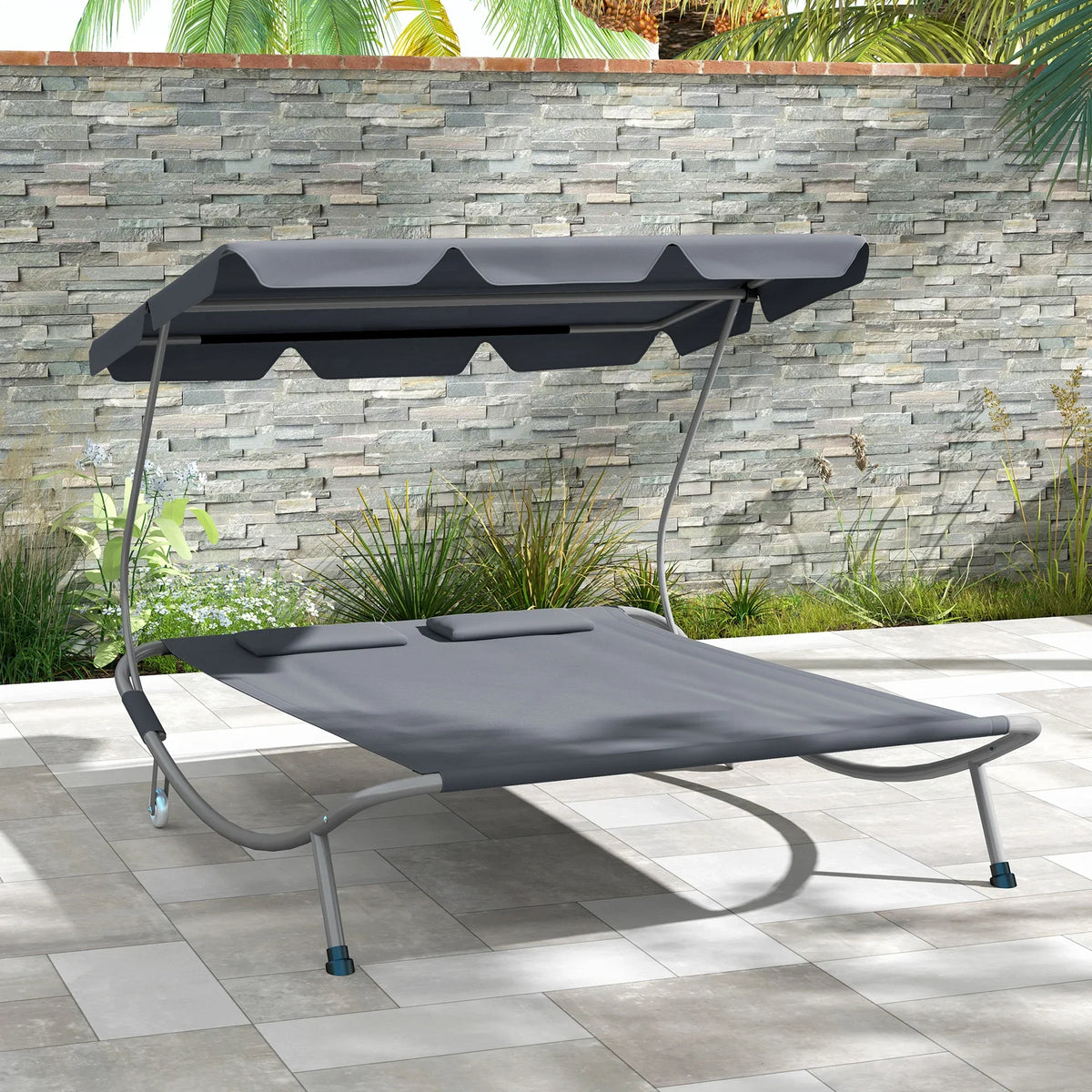 Light grey double outdoor daybed with dark canopy top and padded seat cushions, rolling wheels