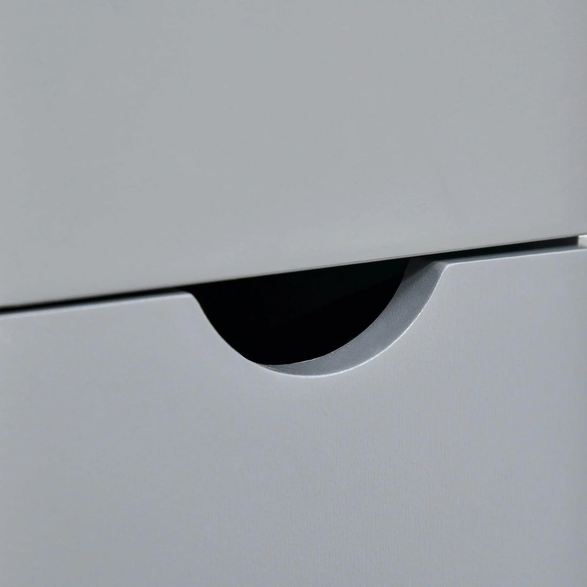 Grey bathroom cabinet drawer front with curved recessed handle