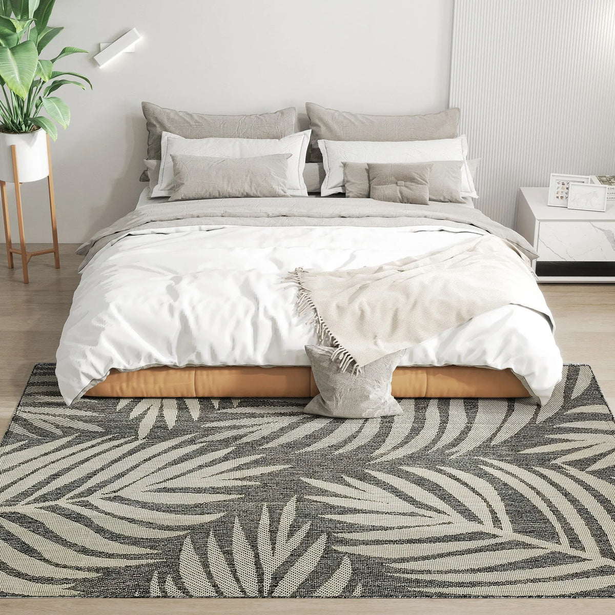 Grey rectangular area rug with bold leaf pattern, textured woven look.