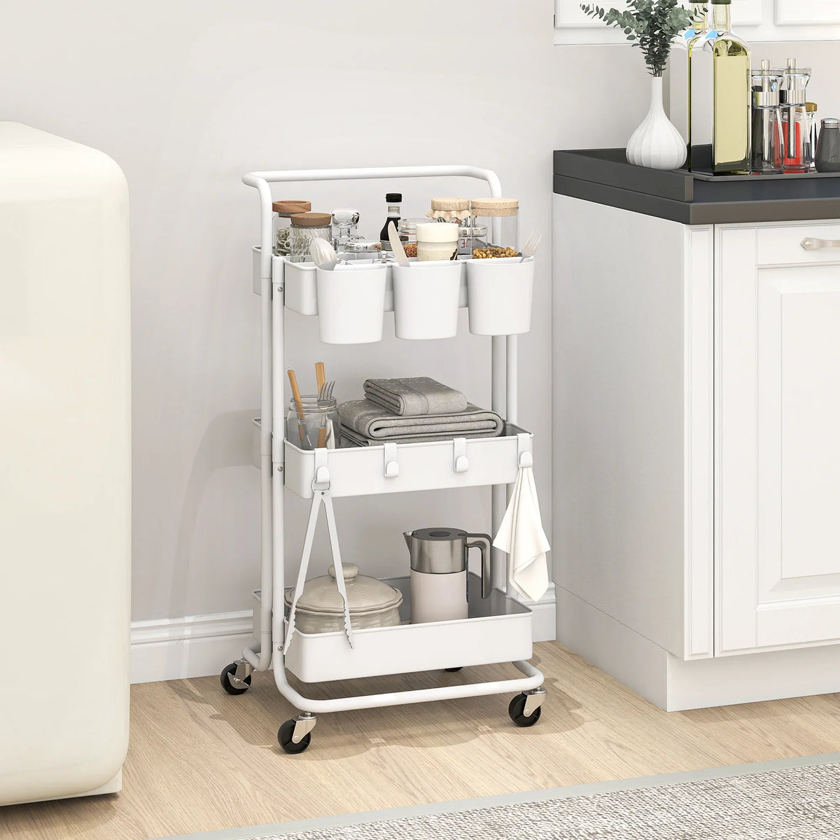 White three-tier trolley cart with handle, baskets, and hanging accessory storage