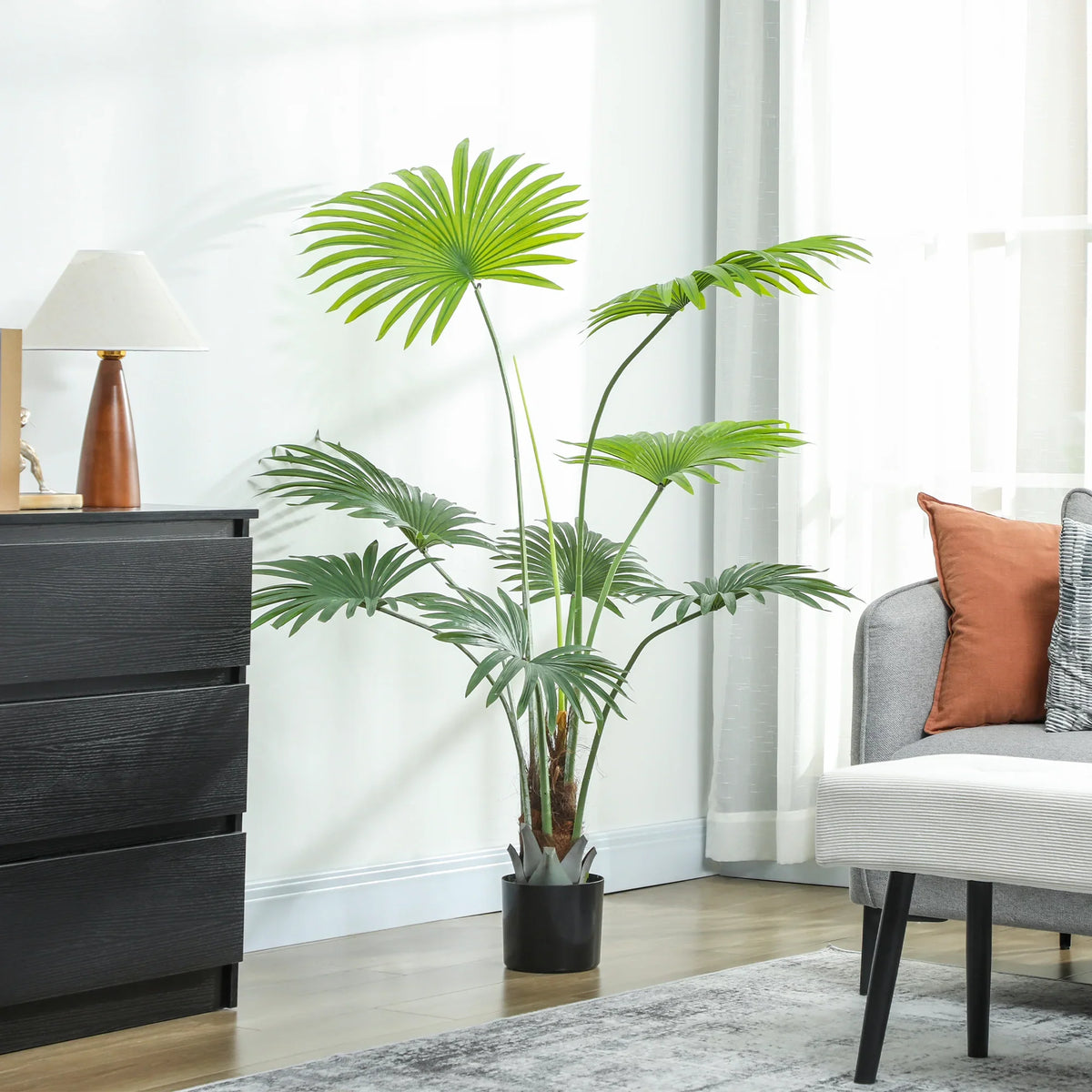 Artificial palm tree with green leaves and trunk in a black pot