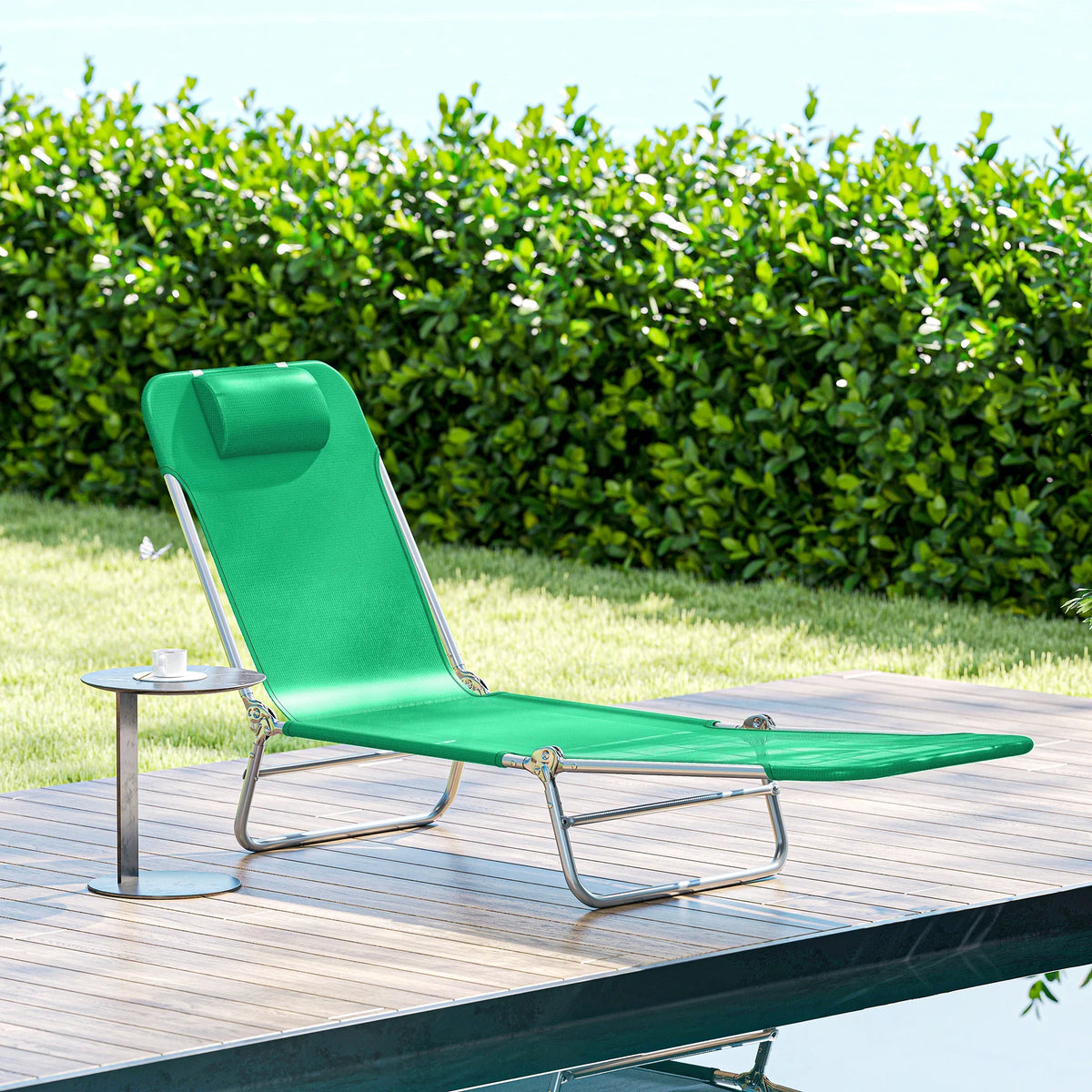 Green folding sun lounger with reclining backrest and mesh seat, on outdoor deck