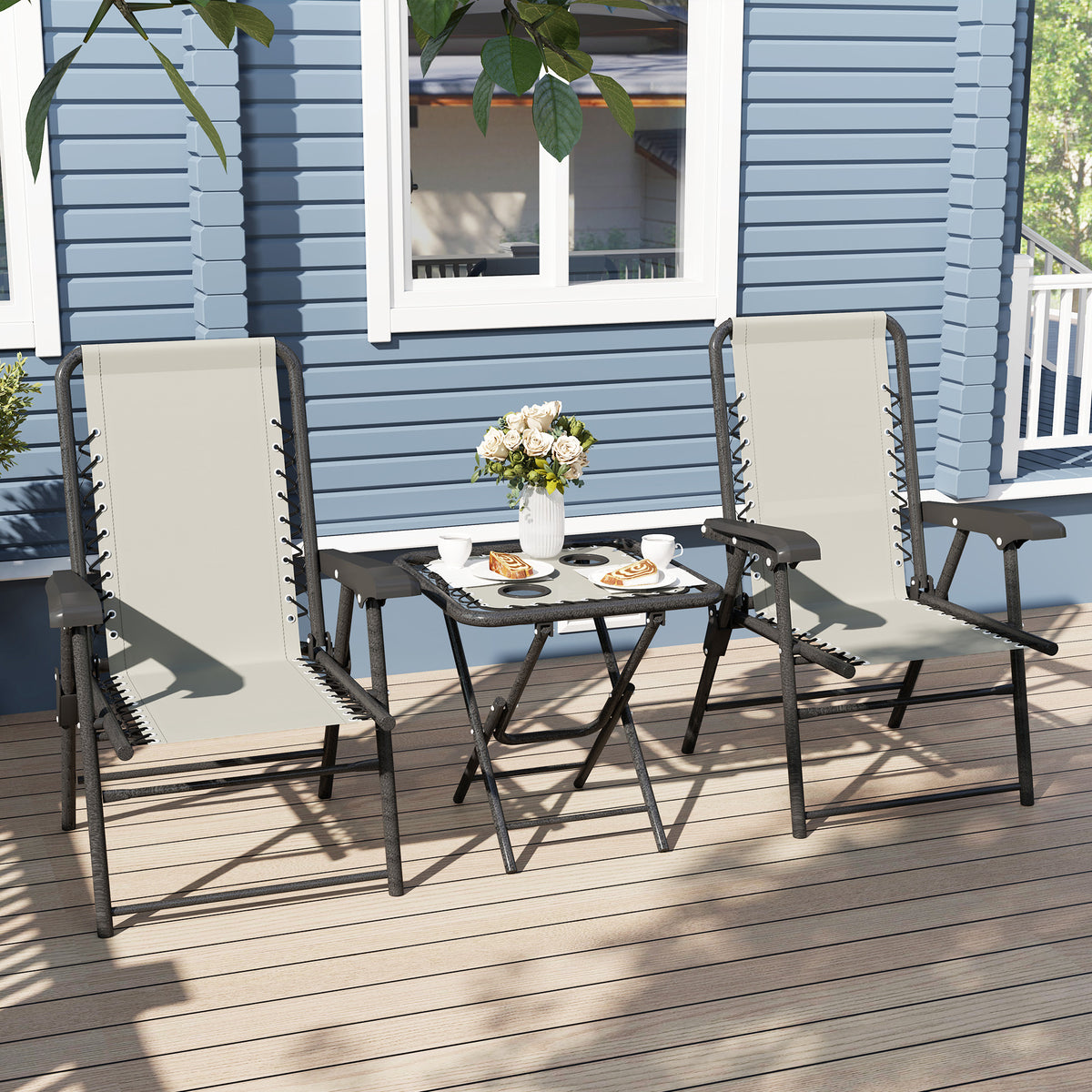 Outdoor patio bistro set with two cream mesh armchairs and black folding table