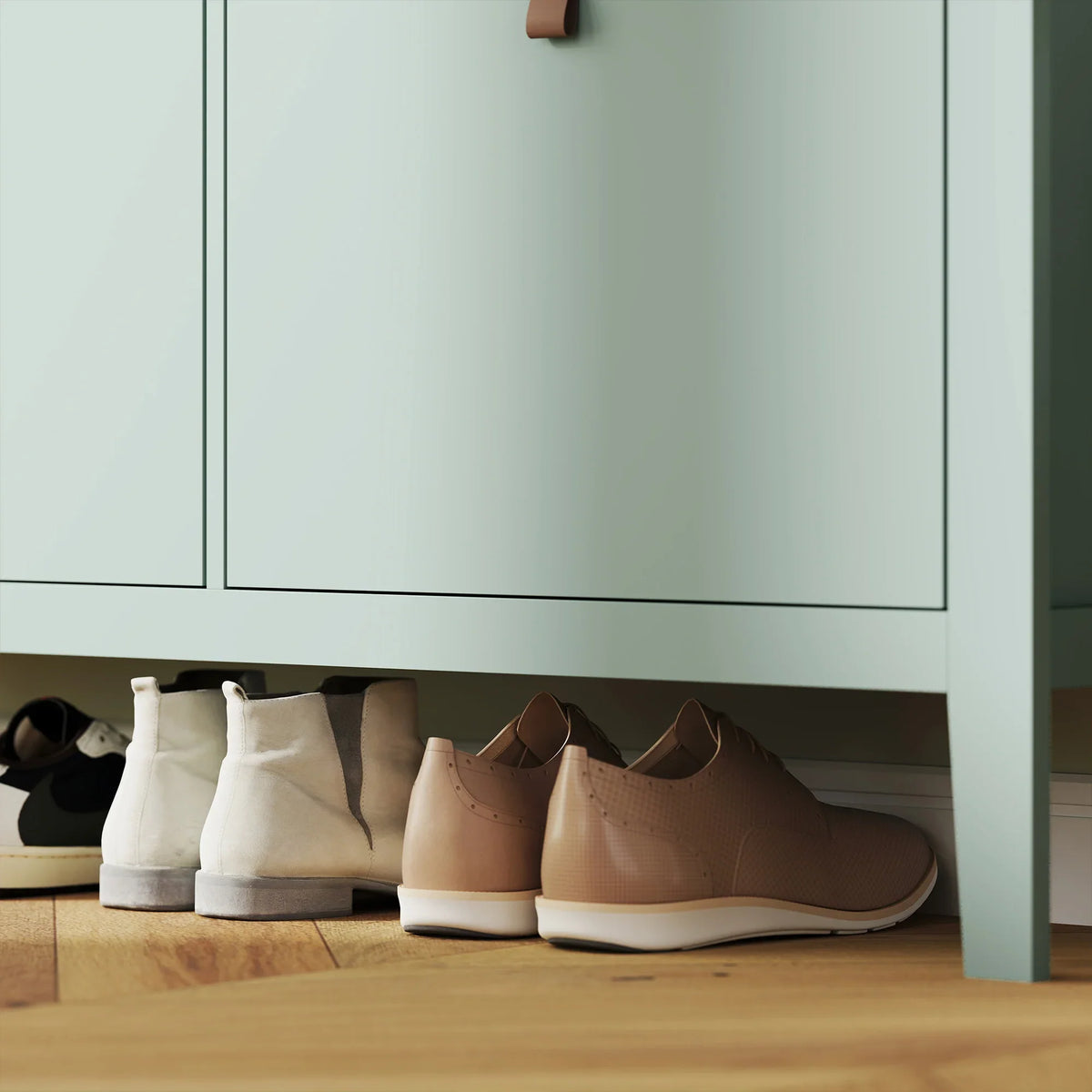 Close-up of shoes stored in a green shoe cabinet compartment under cabinet doors
