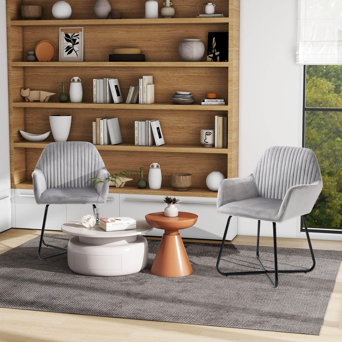 Set of two grey accent armchairs with channel-tufted backs and black metal sled bases.