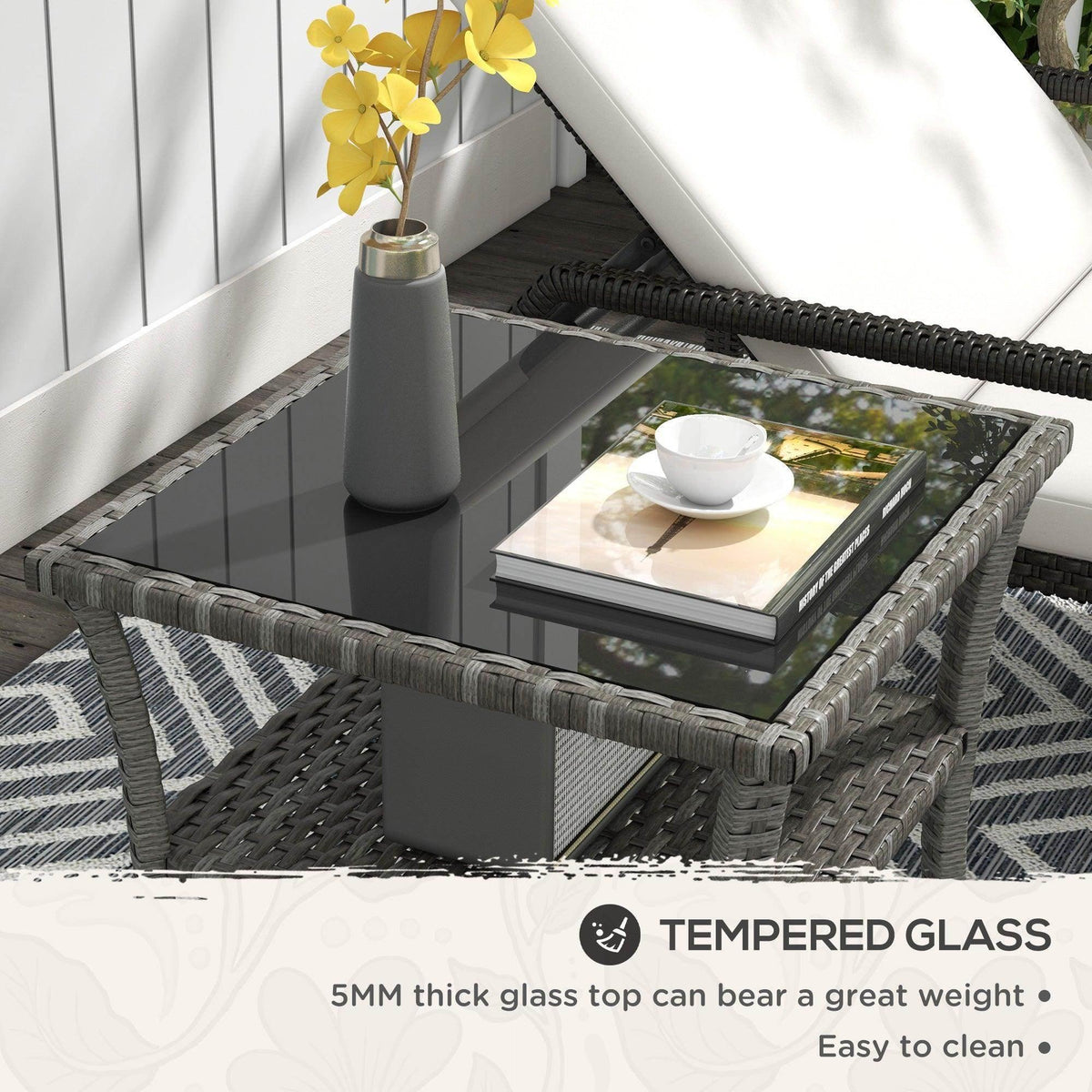 Grey rattan coffee table with clear tempered glass top and two-tier storage shelf