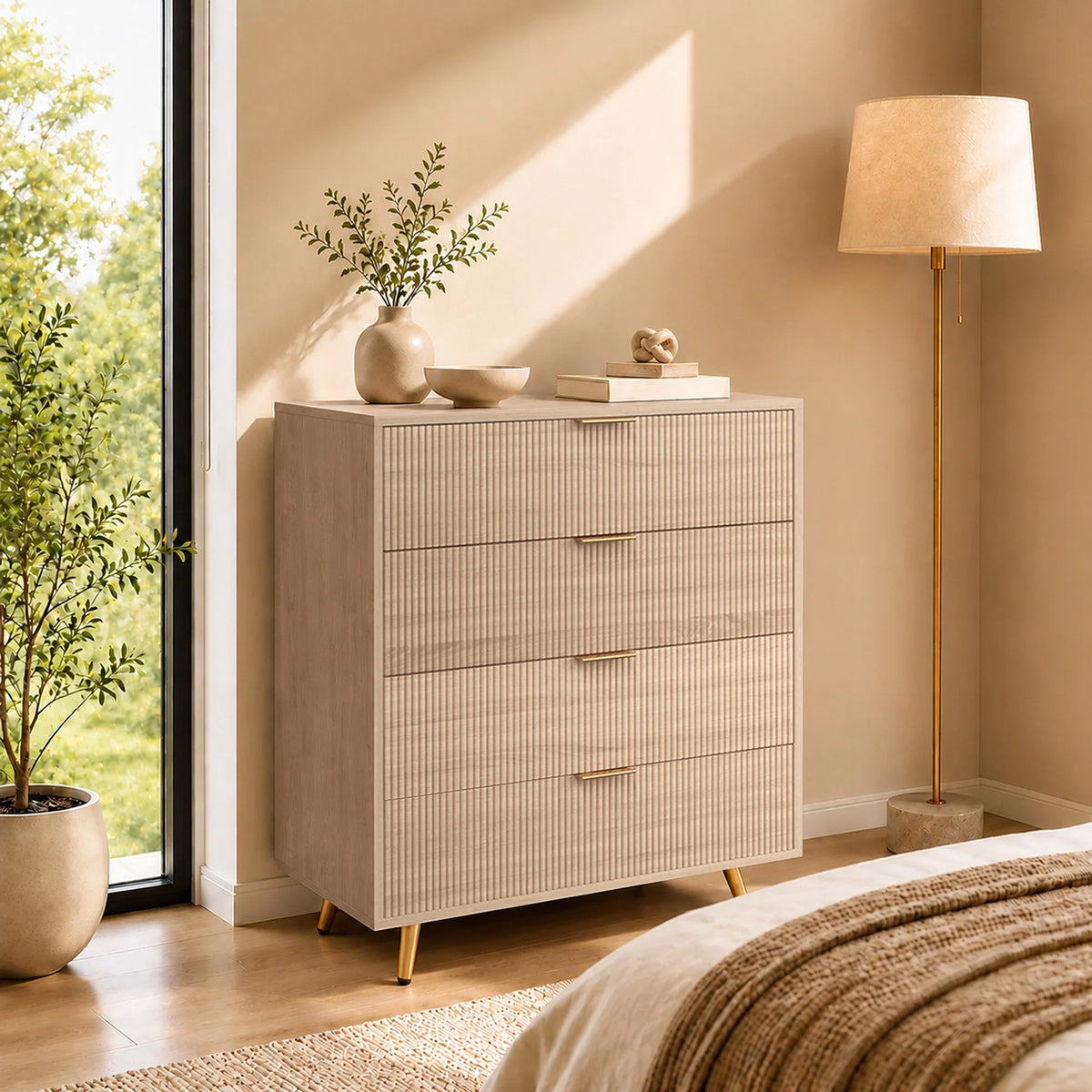 Light wood 4-drawer chest with fluted fronts and gold bar handles.