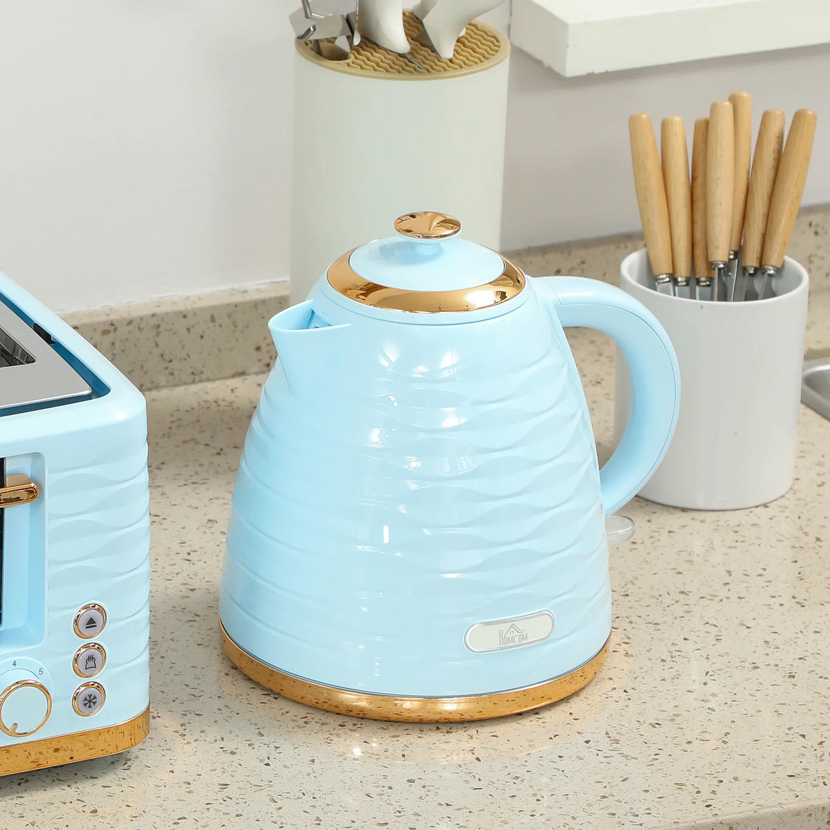 Light blue electric kettle with gold-toned base and curved handle on kitchen counter