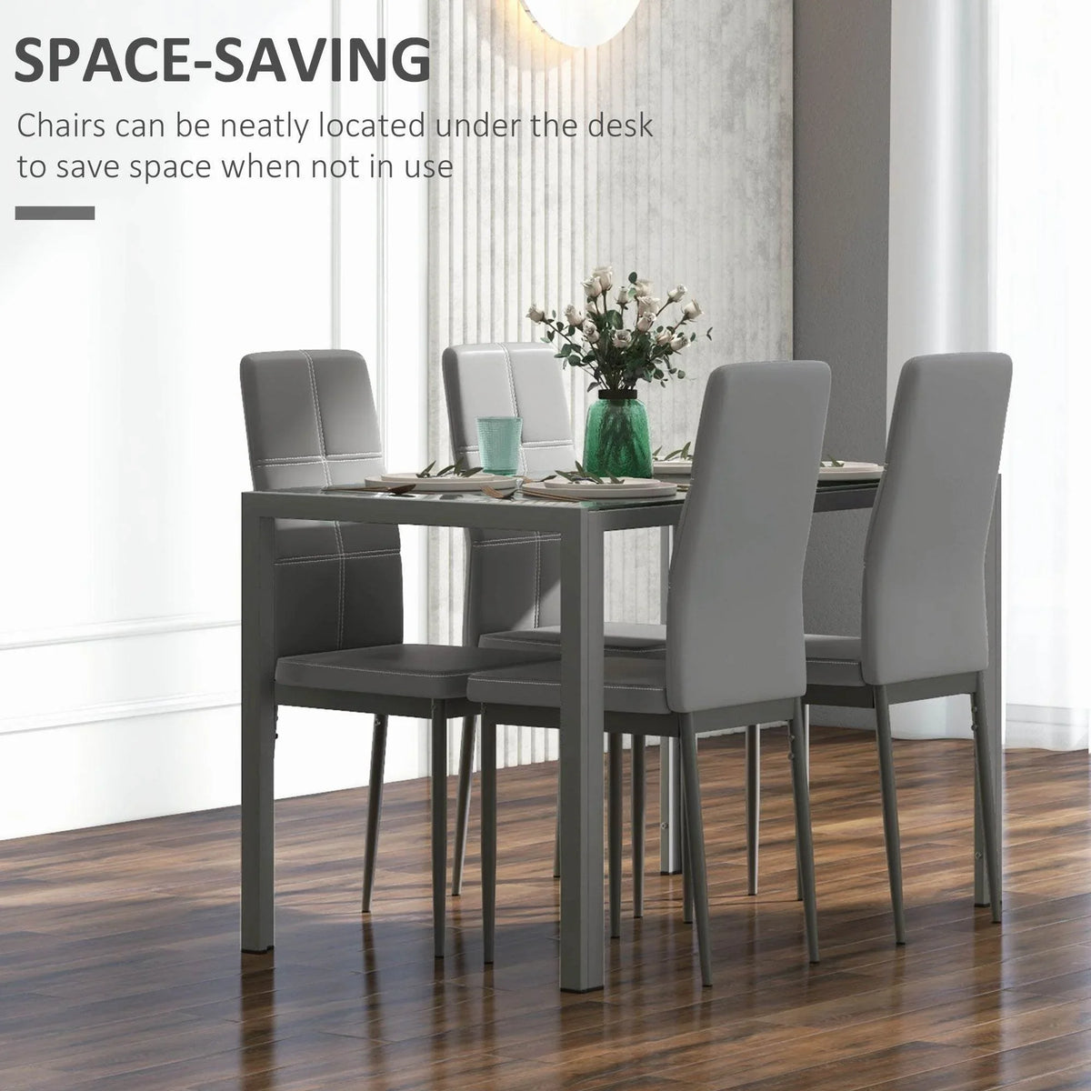 Grey glass-top dining table with four upholstered chairs on metal frames