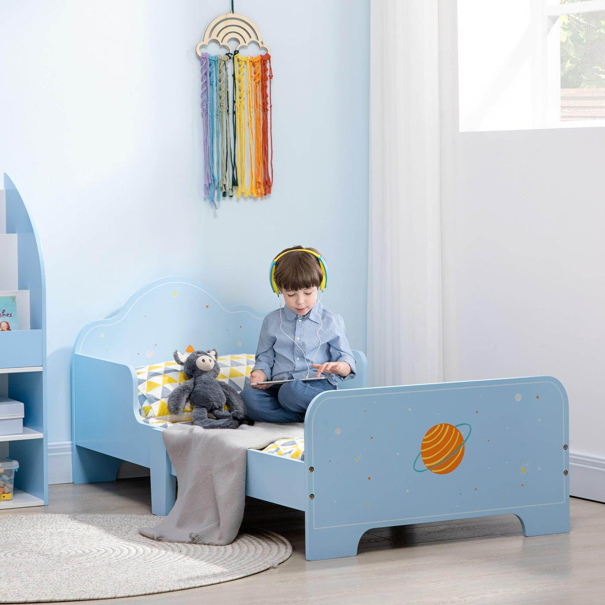 Light blue toddler bed with space-themed panels and rounded headboard