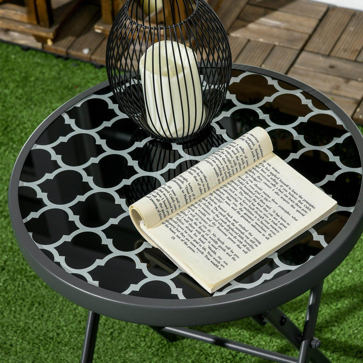 Black round folding side table with geometric glass top