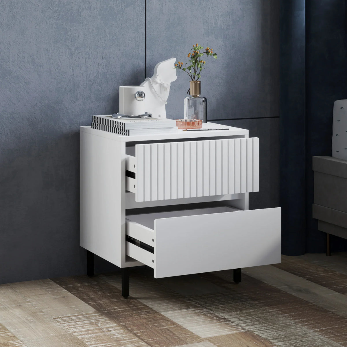 White two-drawer bedside table with open lower drawer and vertical slat cabinet panel