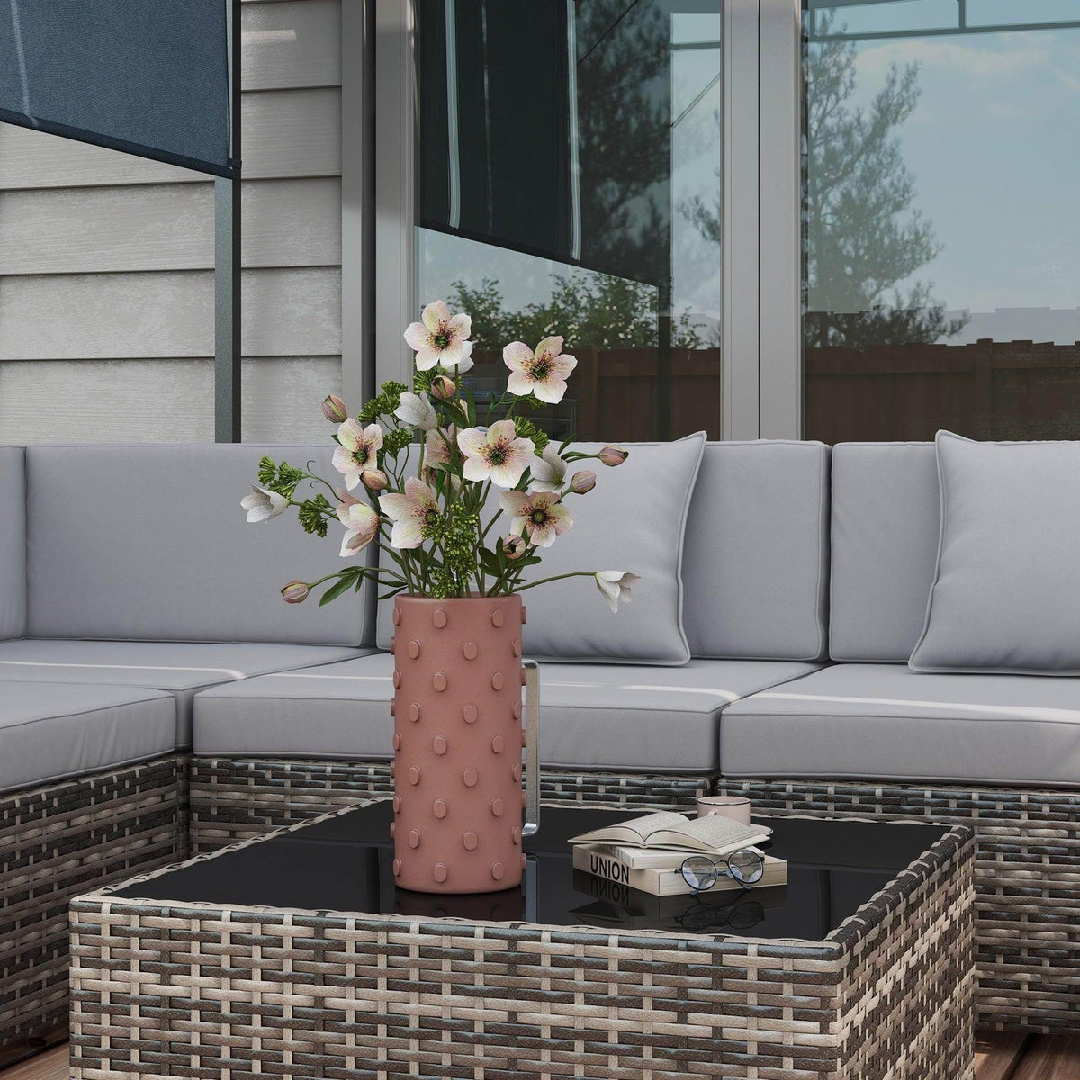 Grey corner sofa set with light grey cushions and glass coffee table