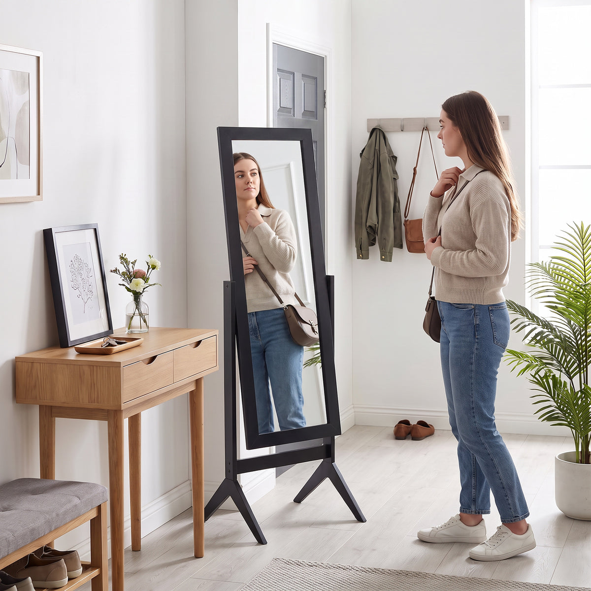 Standing black dressing mirror with full-body view on adjustable legs.