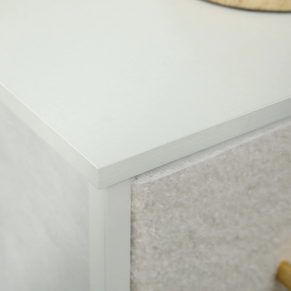 Cream white dresser top corner with textured boucle side panel and clean edge trim