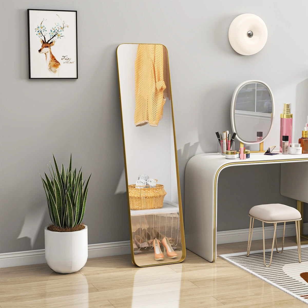 Full-length rectangular mirror with gold-tone frame, reflecting vanity and room decor
