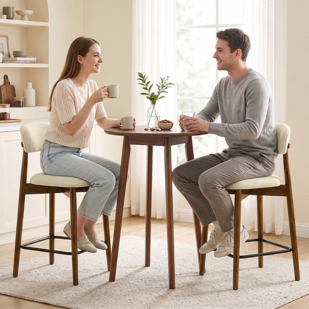 Pair of beige bar stools with curved backs, cushioned seats, and black footrests