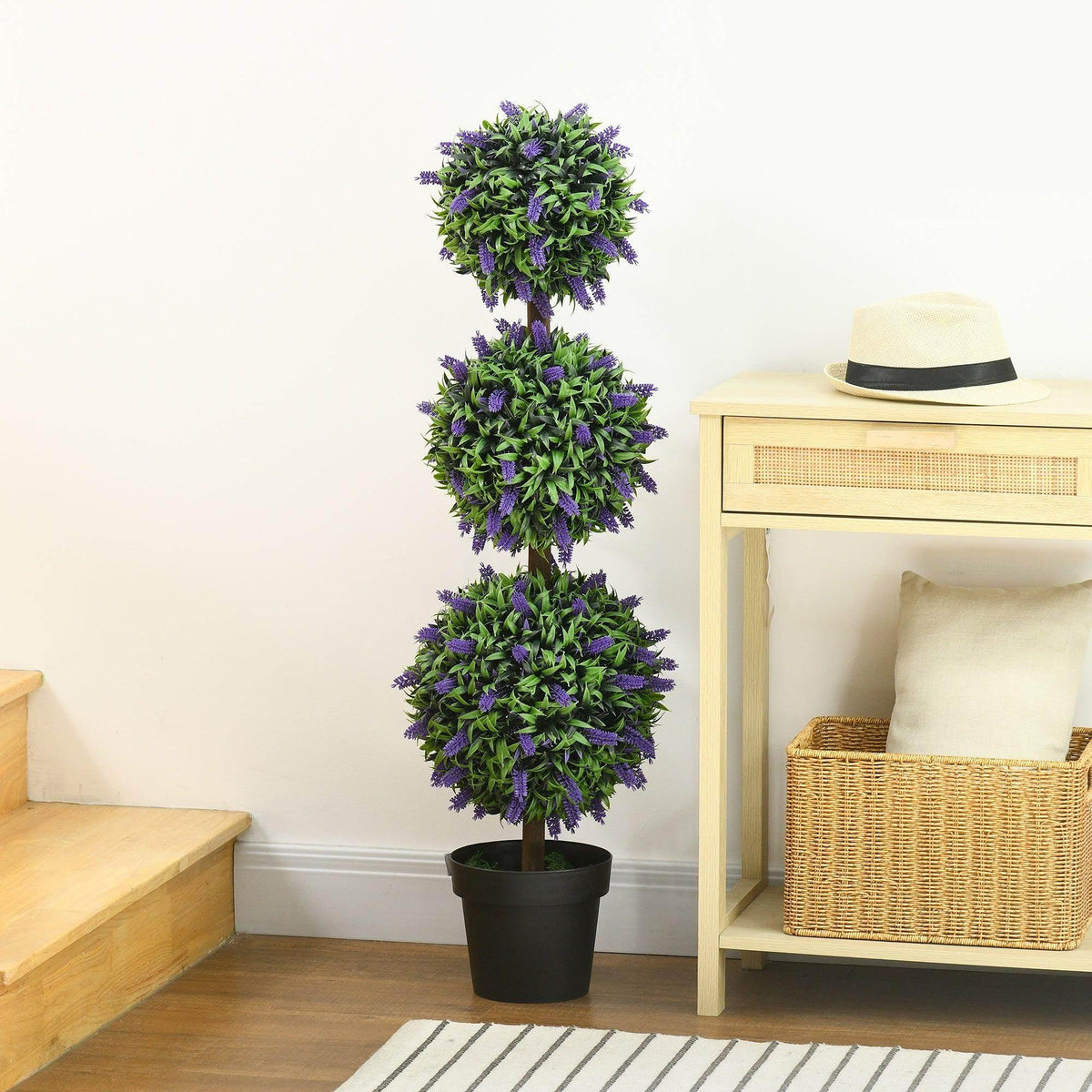 Artificial potted ball tree with layered purple blossoms and green leaves, in black pot