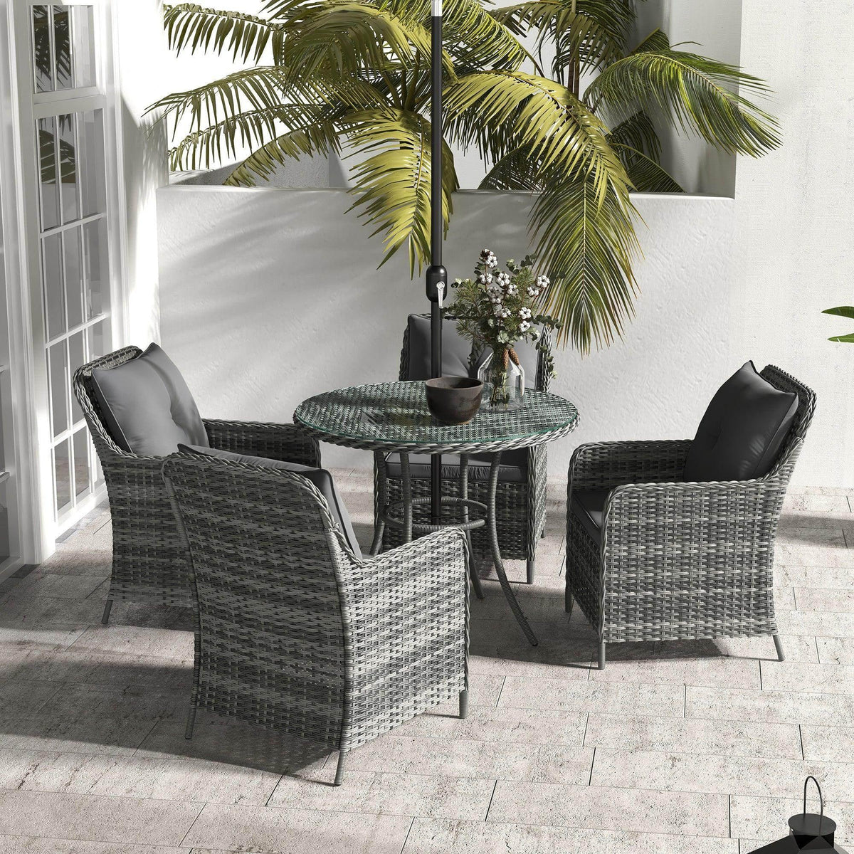 Outdoor dining set with umbrella, gray wicker chairs, round glass-top table, dark cushions
